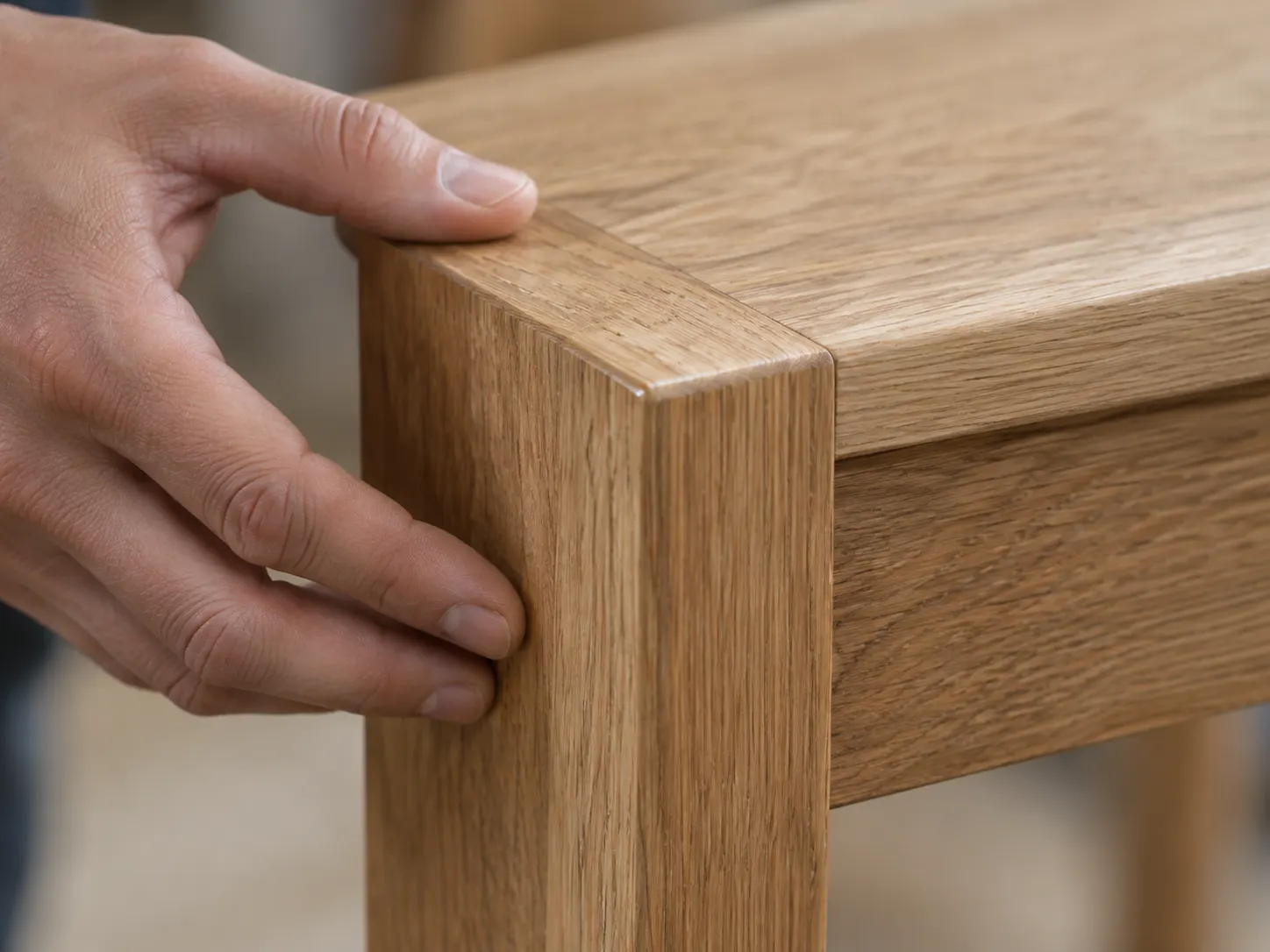 Close-up of solid oak corner joint showing tight fit and wood grain on finished furniture